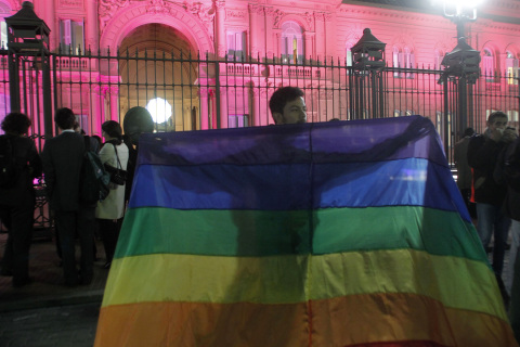 A demonstrator waves a gay pride flag in front of the government palace in Buenos Aires